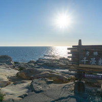 光に照らされる千畳敷と広大な海原の写真