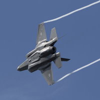 機体下面に光を受け翼端からベイパーを伸ばし青空を引き裂くF35の写真