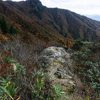 突き出した岩場から眼下に広がる山並み（冠山峠）の写真