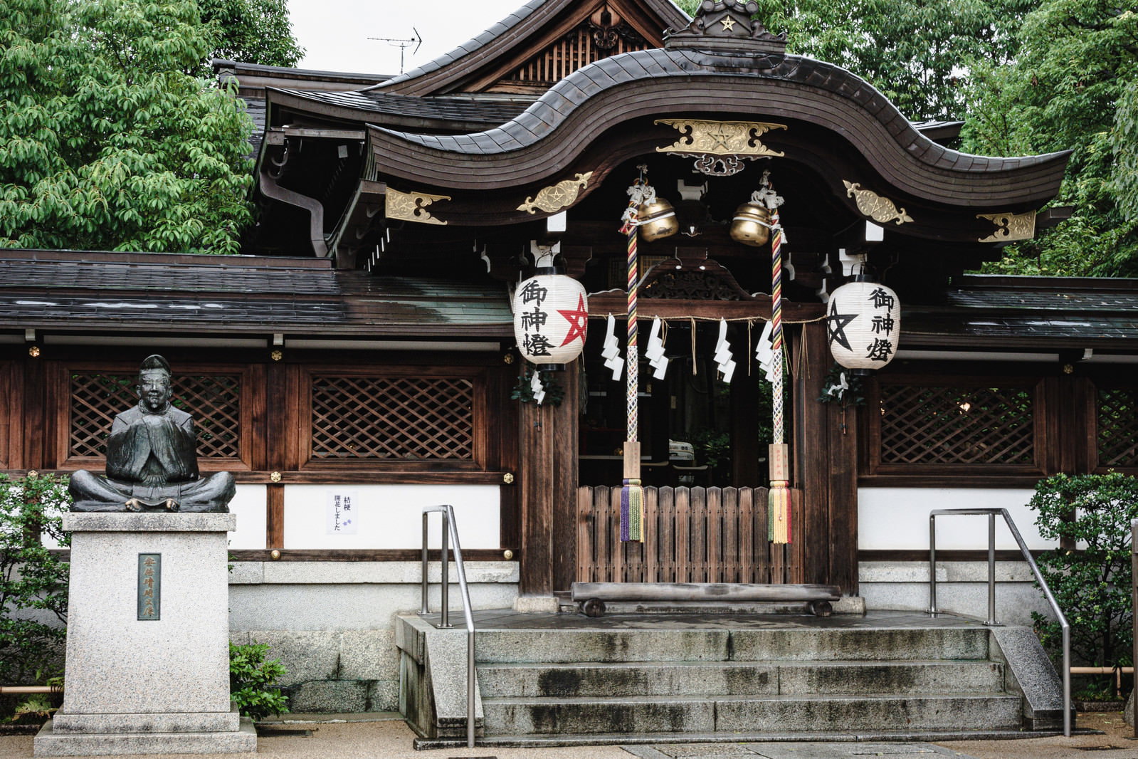 清明神社境内の安倍晴明公の像と背景の本殿