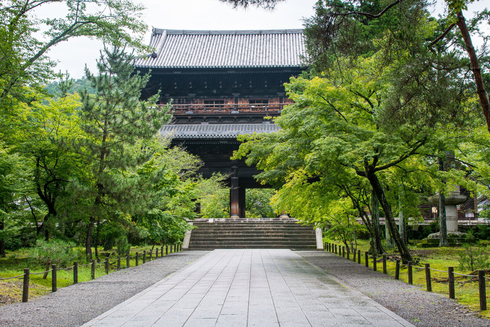 The Sanmon Gate of Kyoto's Nanzenji Temple surrounded by fresh greenery and a cobblestone path