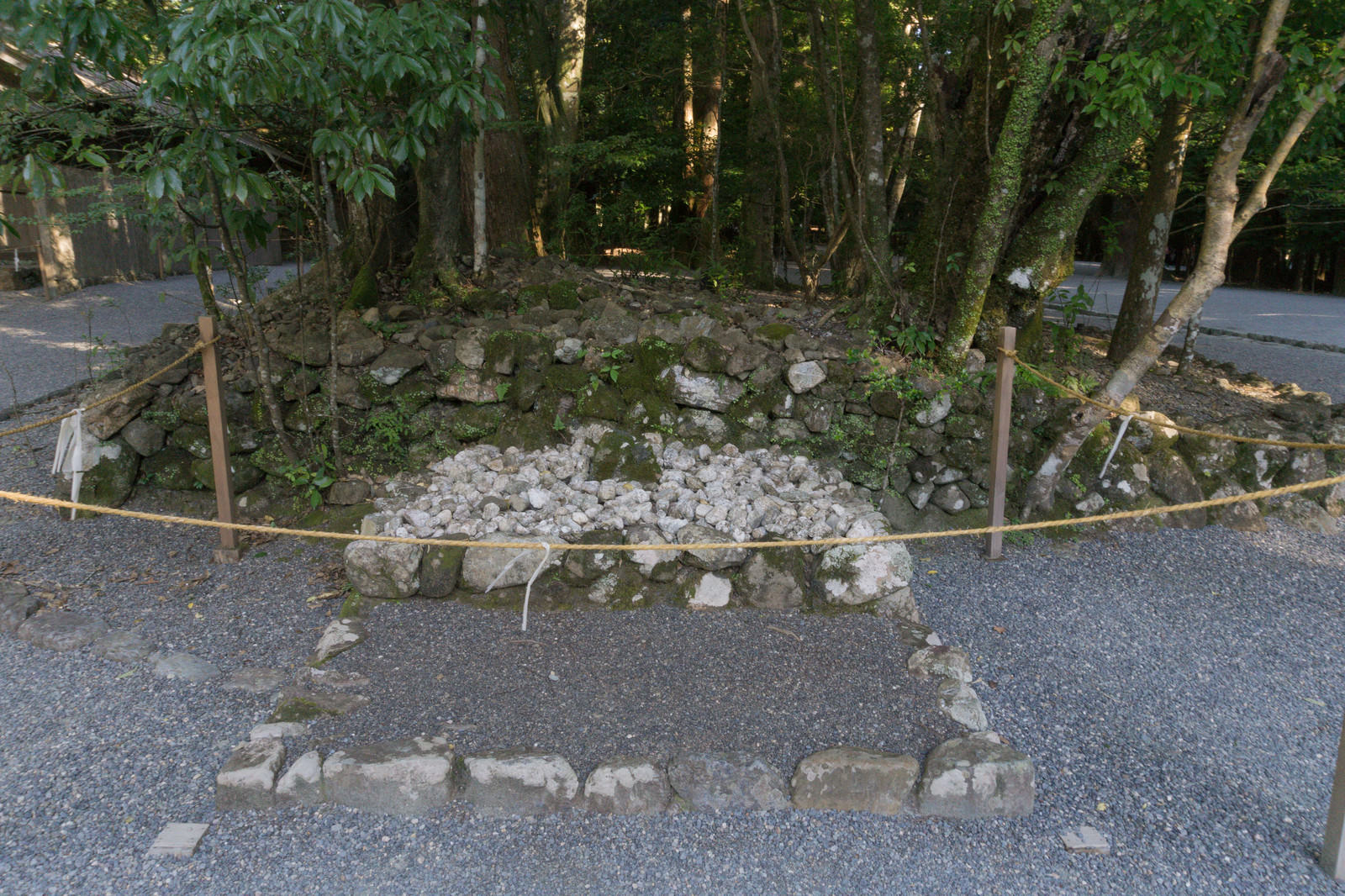 石垣に囲まれた四至神の神聖な境内、玉砂利と森林に囲まれた空間