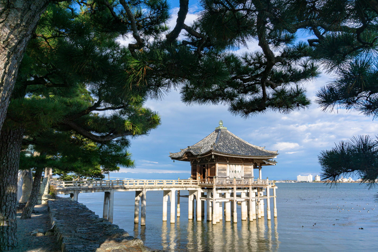 琵琶湖に浮かぶ浮御堂と松の木が水面に反射する静寂な湖畔風景