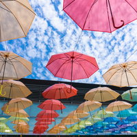 宙に浮くカラフルなビニール傘の写真