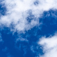 晴れの日に流れる白い雲の写真